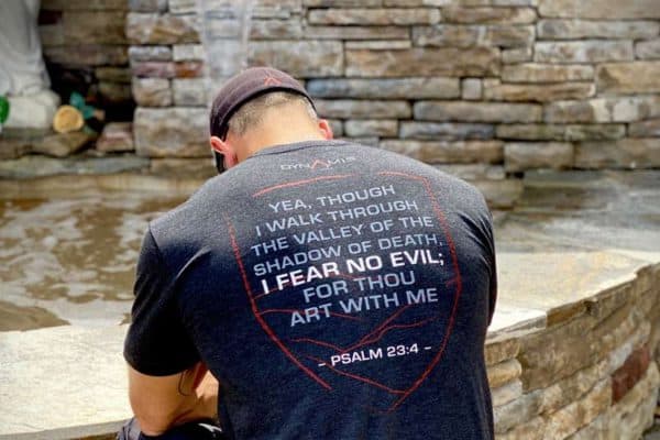 Navy SEAL Dom Raso praying, showing the back of fearless knight t shirt which shows Psalm 23:4. The purpose of this image is decorative.
