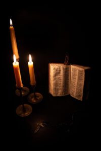 Three candles with a Bible and a Rosary